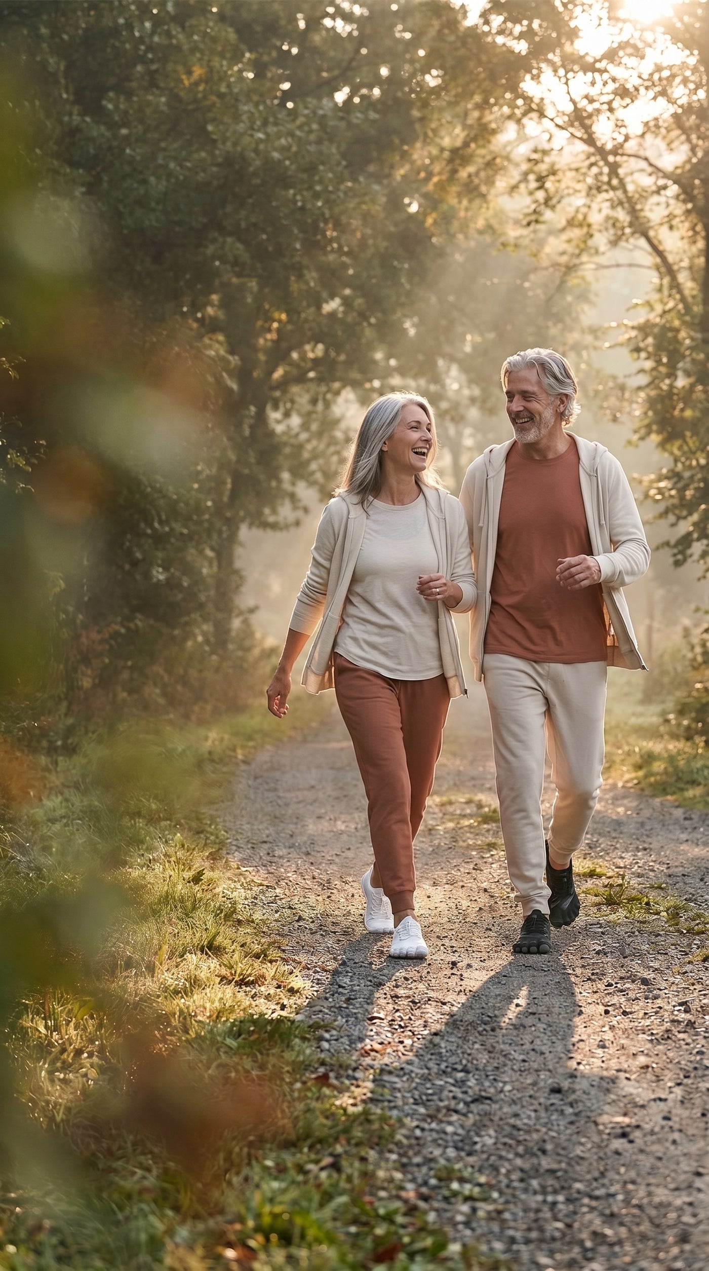 Couple in their 60s walking comfortably on a sunlit path